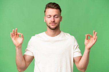 Zen pozisyonunda, izole edilmiş bir geçmişi olan genç sarışın, beyaz bir adam.