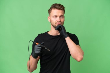 Dövme sanatçısı beyaz bir adam izole edilmiş arka planda ve araştırıyor