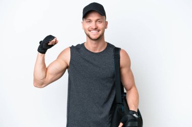 Sarışın, beyaz tenli, spor çantalı beyaz tenli, güçlü bir jest yapan genç bir adam.