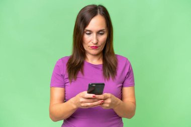 Orta yaşlı beyaz bir kadın cep telefonu kullanıyor.