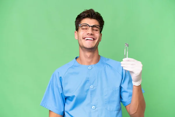 Jovem Dentista Homem Segurando Ferramentas Sobre Fundo Isolado Rindo — Fotografia de Stock
