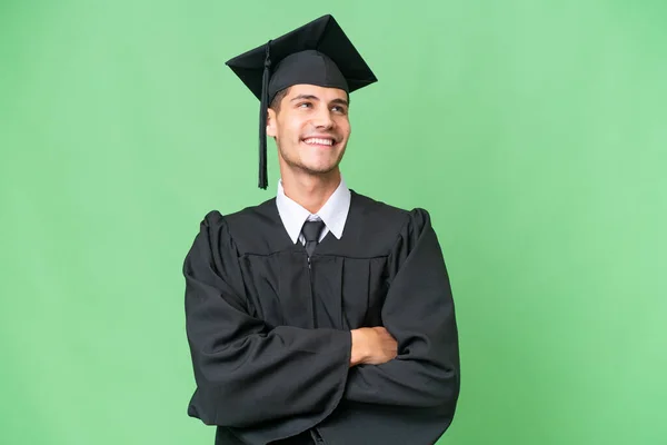 Jonge Universiteit Afgestudeerde Kaukasische Man Geïsoleerde Achtergrond Kijken Omhoog Terwijl — Stockfoto