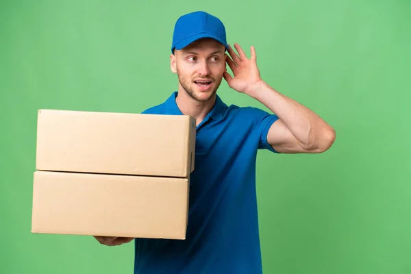Delivery Caucasian Man Isolated Background Listening Something Putting Hand Ear — Stock Photo, Image