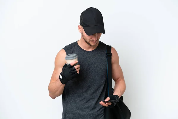 年轻的金发碧眼的白人男子 背着运动包 独立的白色背景 手里拿着咖啡和手机 — 图库照片