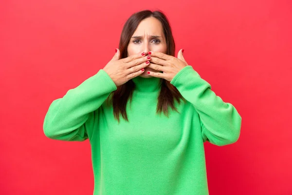 stock image Middle-aged caucasian woman isolated on red background covering mouth with hands