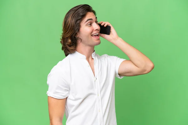 Young Caucasian Man Isolated Green Chroma Background Keeping Conversation Mobile — Stock Photo, Image