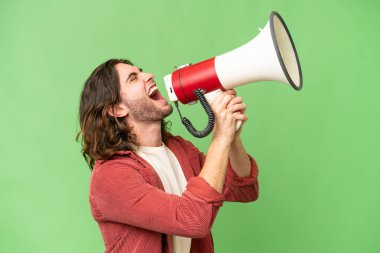 Izole arka plan üzerinde genç yakışıklı adam bir megafon ile bağırıyor