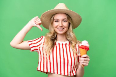 Kornet dondurması ile izole edilmiş arka planda gururlu ve kendini beğenmiş genç bir İngiliz kadın.