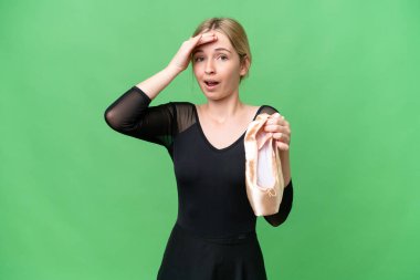 Soyutlanmış arka planda bale yapan genç bir İngiliz kadın yan tarafa bakarken sürpriz jest yapıyor.