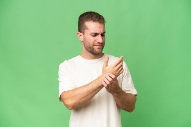 Yeşil krom arka planda izole edilmiş yakışıklı, beyaz bir adam ellerinde acıdan muzdarip.