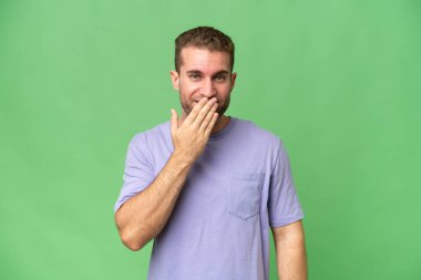 Yeşil krom arka planda izole edilmiş yakışıklı beyaz adam mutlu ve gülümsüyor.