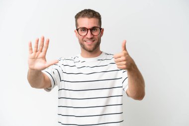 Beyaz arka planda izole edilmiş yakışıklı beyaz adam parmakları olan altı kişi sayıyor.
