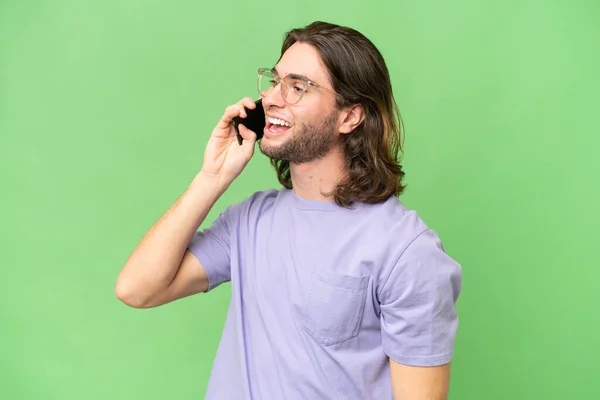 Молодой Красивый Мужчина Изолированном Фоне Поддерживает Разговор Кем Мобильному Телефону — стоковое фото