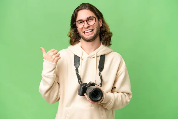Mladý Fotograf Přes Izolované Pozadí Ukazuje Stranu Aby Prezentovat Produkt — Stock fotografie