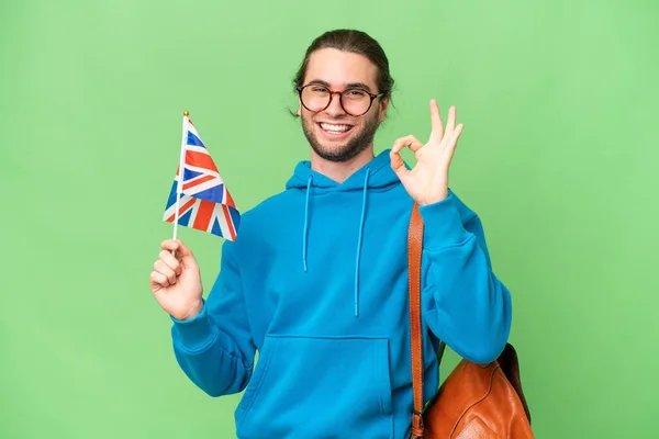 Mladý Pohledný Muž Drží Britskou Vlajku Nad Izolovaným Pozadím Ukazuje — Stock fotografie