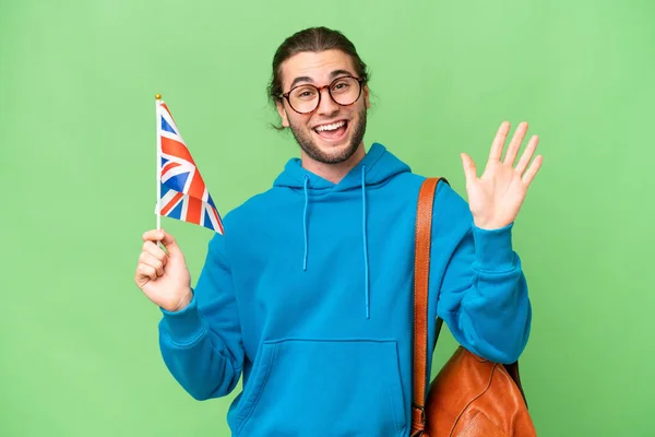 Mladý Pohledný Muž Drží Britskou Vlajku Nad Izolované Pozadí Salutování — Stock fotografie