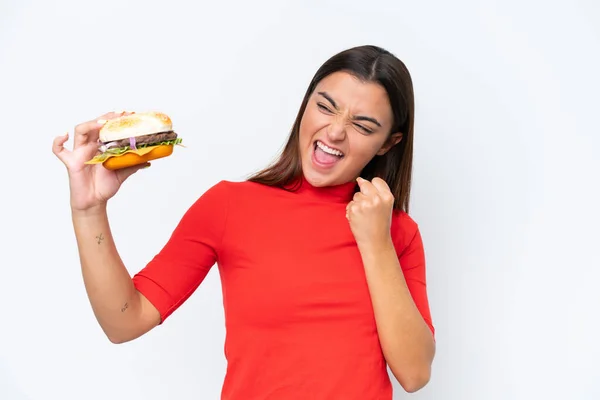 Jonge Kaukasische Vrouw Houden Een Hamburger Geïsoleerd Witte Achtergrond Vieren — Stockfoto