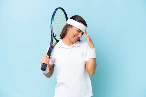 若いテニスプレーヤーの女性隔離上の青の背景笑い — ストック写真