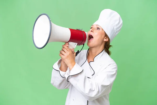 stock image Middle-aged chef woman over isolated background shouting through a megaphone