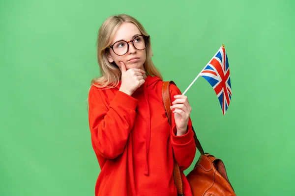 Mladá Hispánská Žena Drží Britskou Vlajku Nad Izolovaným Pozadím Pochybnostmi — Stock fotografie