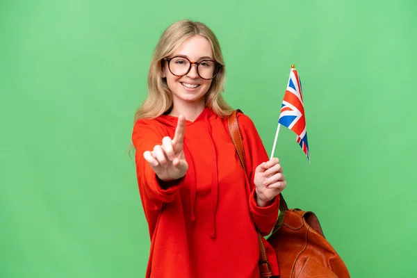 Молодая Латиноамериканка Держит Флаг Великобритании Изолированном Фоне Показывая Показывая Пальцем — стоковое фото