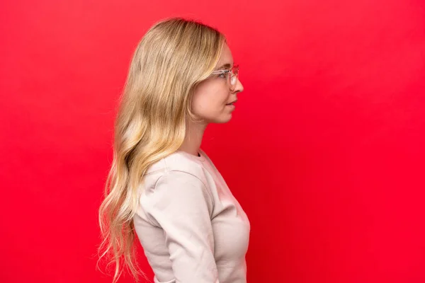 Kırmızı Arka Planda Gözlüklü Genç Ngiliz Kadın — Stok fotoğraf