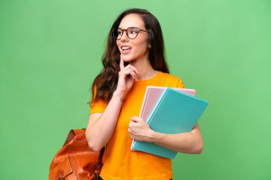 Young student caucasian woman over isolated background thinking an idea while looking up
