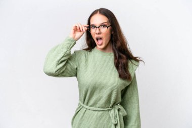 Beyaz arka planda gözlüklü ve şaşırmış genç beyaz kadın.