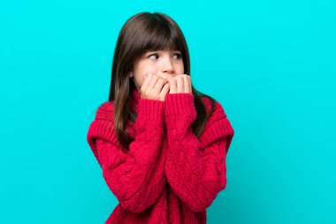 Küçük beyaz kız mavi arka planda izole edilmiş gergin ve korkmuş bir şekilde elleriyle suni teneffüs yapıyor.