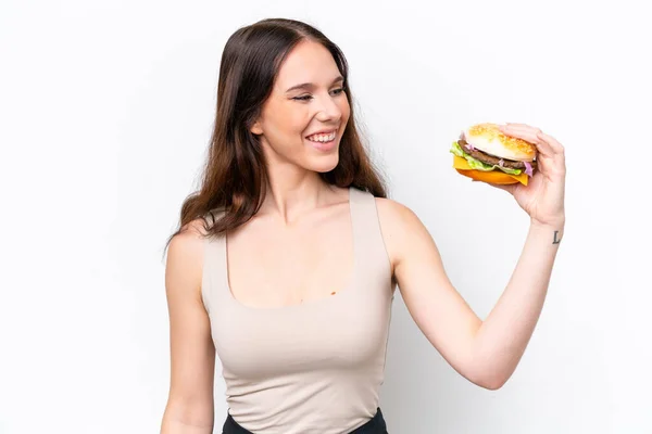 Młoda Kaukaska Kobieta Trzyma Hamburgera Białym Tle Szczęśliwą Ekspresją — Zdjęcie stockowe