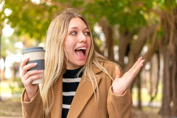 Mladý Pěkný Blondýnka Žena Drží Odnést Kávu Venku Překvapením Výraz — Stock fotografie