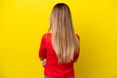 Genç Uruguaylı kadın sarı arka planda izole edilmiş.