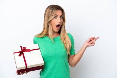 Genç Uruguaylı kadın elinde beyaz arka planda izole edilmiş bir hediye tutuyor.