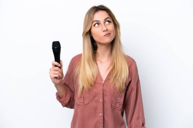 Şarkıcı Uruguaylı kadın beyaz arka planda izole edilmiş bir mikrofonu kaldırıyor ve