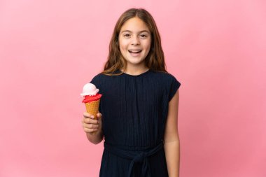 Kornet dondurması olan bir çocuk pembe arka planda ve yüzünde sürpriz bir ifade var.