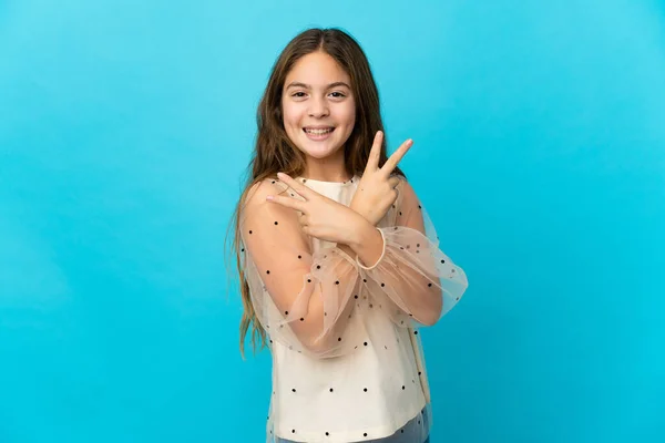 Klein Meisje Geïsoleerde Blauwe Achtergrond Glimlachen Tonen Overwinning Teken — Stockfoto