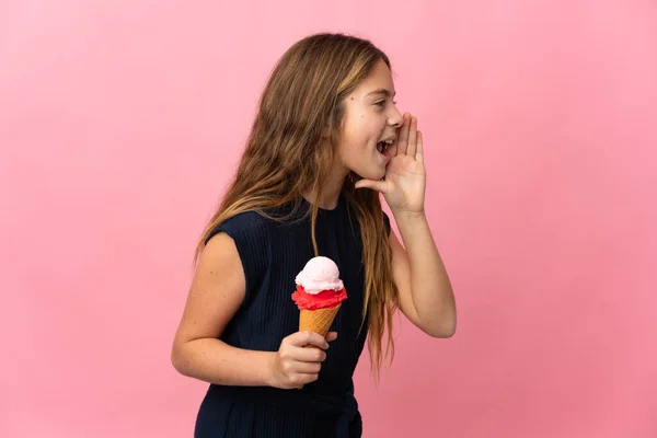 子供とともにCornetアイスクリーム以上隔離されたピンクの背景叫びますとともに口を大きく開きます側面 — ストック写真