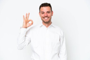 Beyaz arka planda izole edilmiş beyaz tenli yakışıklı bir adam parmaklarıyla işaret veriyor.