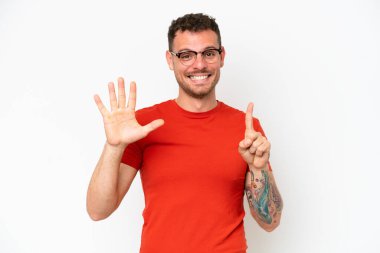 Beyaz arka planda izole edilmiş beyaz tenli yakışıklı adam parmakları olan altı kişi sayıyor.