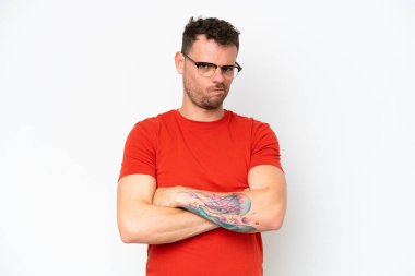 Beyaz arka planda, mutsuz bir ifadeyle soyutlanmış beyaz, beyaz, yakışıklı bir adam.