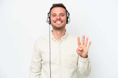 Beyaz arka planda kulaklıkla çalışan beyaz pazarlamacı beyaz adam mutlu ve parmaklarıyla dört kişi sayıyor.