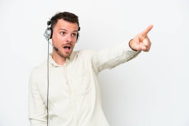 Beyaz arka planda izole edilmiş bir kulaklıkla çalışan beyaz pazarlamacı.