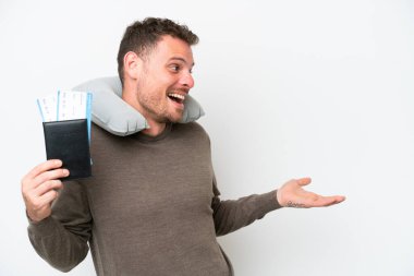 Beyaz arka planda pasaport taşıyan genç beyaz bir adam.