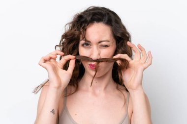 Beyaz arka planda izole edilmiş genç beyaz kadın saçlarına dokunuyor. Portreyi kapat