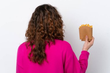 Beyaz arka planda izole edilmiş, patates kızartması yakalayan beyaz bir kadın.