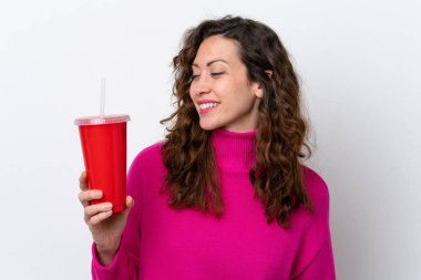 Beyaz arka planda izole edilmiş gazoz içen beyaz bir kadın.