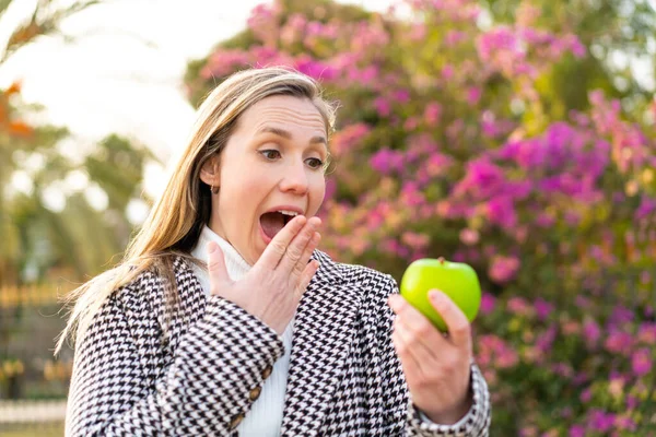 Junge Blonde Frau Mit Einem Apfel Freien Überrascht Und Schockiert — Stockfoto