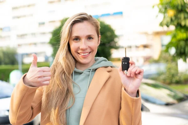 Νεαρή Ξανθιά Γυναίκα Που Κρατάει Κλειδιά Αυτοκινήτου Στην Ύπαιθρο Σηκωμένους — Φωτογραφία Αρχείου