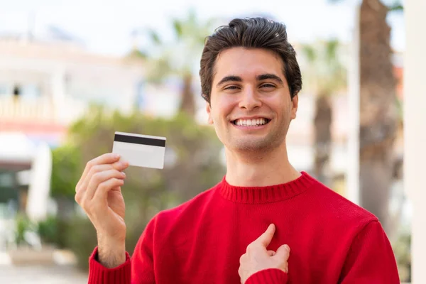 Young Handsome Man Holding Credit Card Outdoors Surprise Facial Expression — Stock Photo, Image