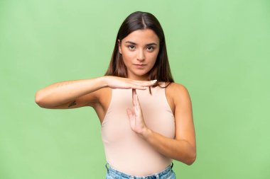 Genç beyaz kadın yeşil krom arka planda izole edilmiş.